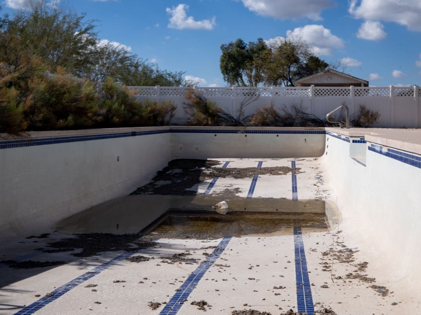 Empty, neglected backyard swimming pool in Arizona
